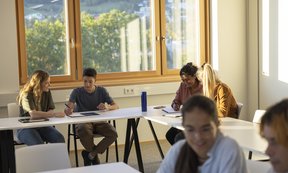 Einige Schüler und Schülerinnen sitzen im Klassenzimmer.