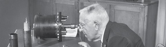 Victor F. Hess blickt in einen Strahlungsapparat