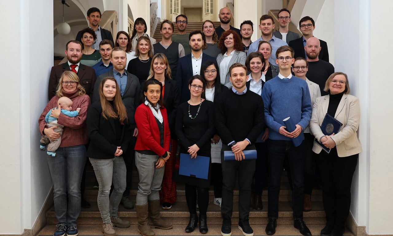 Rund 30 Menschen stehen für ein Gruppenfoto auf einem Treppenaufgang im Hauptgebäude der Universität Innsbruck