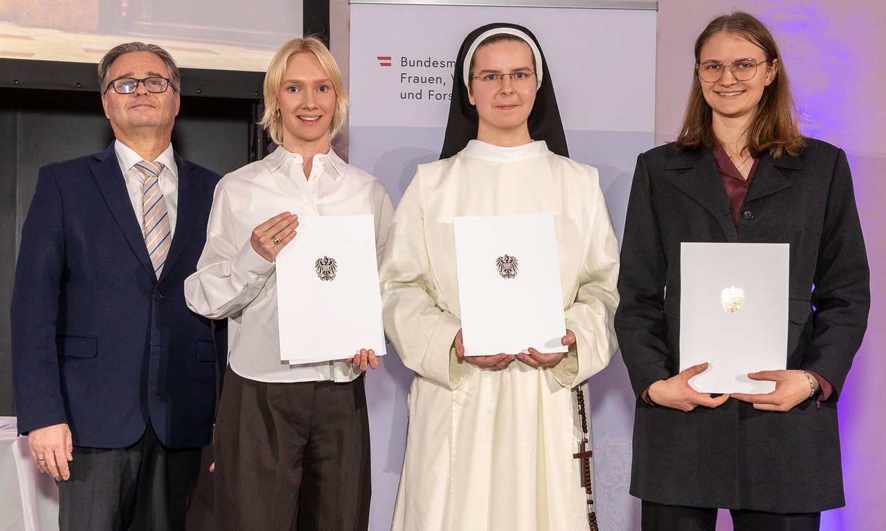 Zu sehen sind Ministerialrat Heribert Wulz und drei junge Wissenschaftlerinnen (Sophie Aue, Julia Notburga Margreiter und Iris Schlick-Steiner). Sie halten Urkunden in den Händen.
