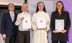 Zu sehen sind Ministerialrat Heribert Wulz und drei junge Wissenschaftlerinnen (Sophie Aue, Julia Notburga Margreiter und Iris Schlick-Steiner). Sie halten Urkunden in den Händen.