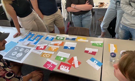 Tisch mit ausgedruckten Piktogrammen und Erklärtexten während einer Lehrveranstaltung