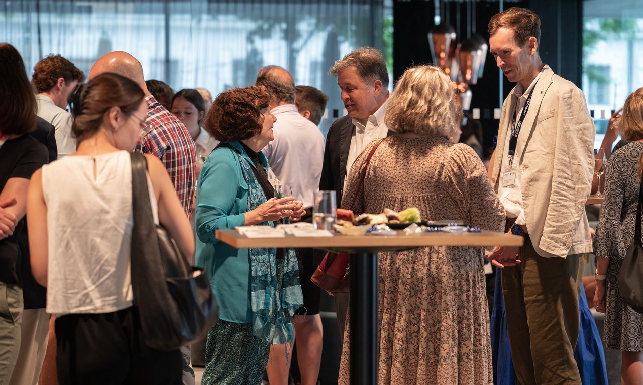 Personen stehen an Stehtischen im Haus der Musik