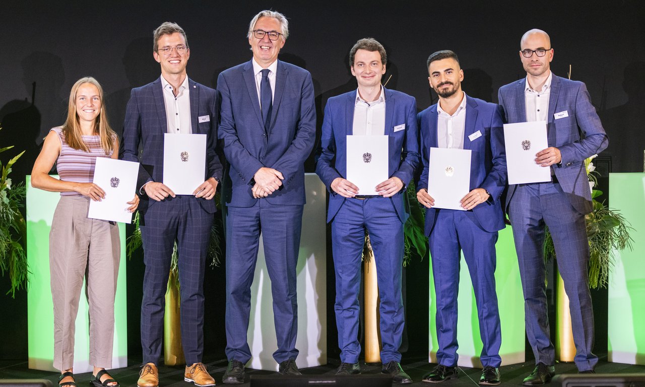 Gruppenfoto von sechs Personen auf einer Bühne.