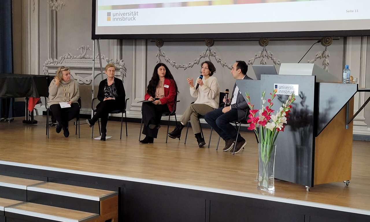 Personen sprechen auf einem Podium