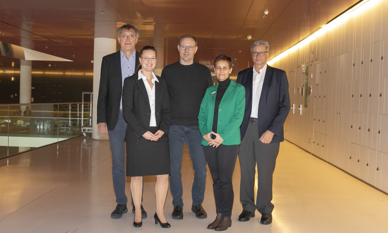 Fünf Menschen stehen für ein Gruppenfoto nebeneinander.
