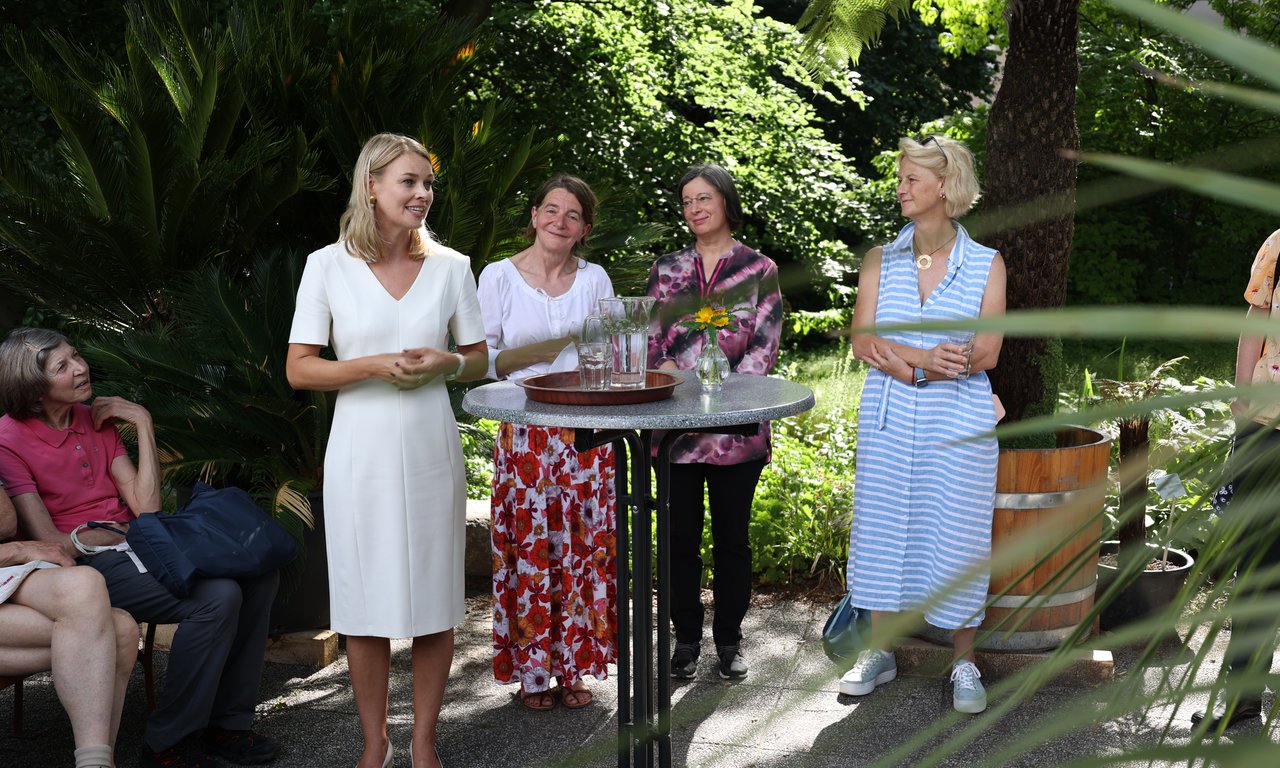Vier Personen stehen um einen Stehtisch