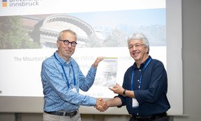 Der Laudator schüttelt die Hand des Preisträgers