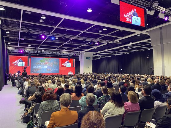 Teilnehmer:innen in einem Saal sitzend von hinten