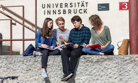 Studierende vor Schriftzug "Universität Innsbruck"