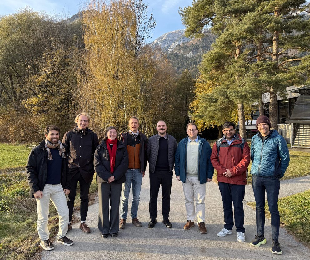 8 Menschen vor dem Institut lächeln in die Kamera