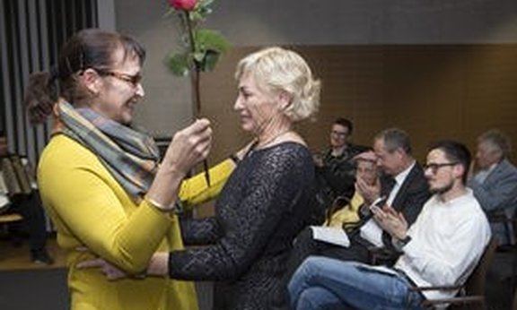 Eine Frau überreicht Erika Thruner eine Rose