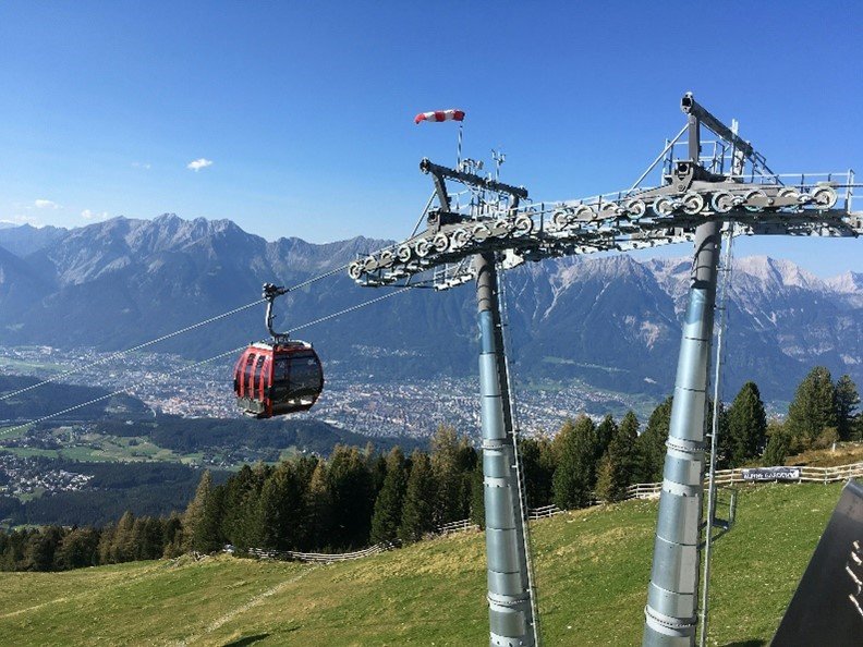 Eine Gondel fährt vor einer Bergkulisse