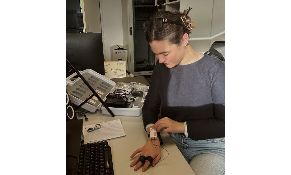 Julia Kugl in front of PC with biosensor equipment