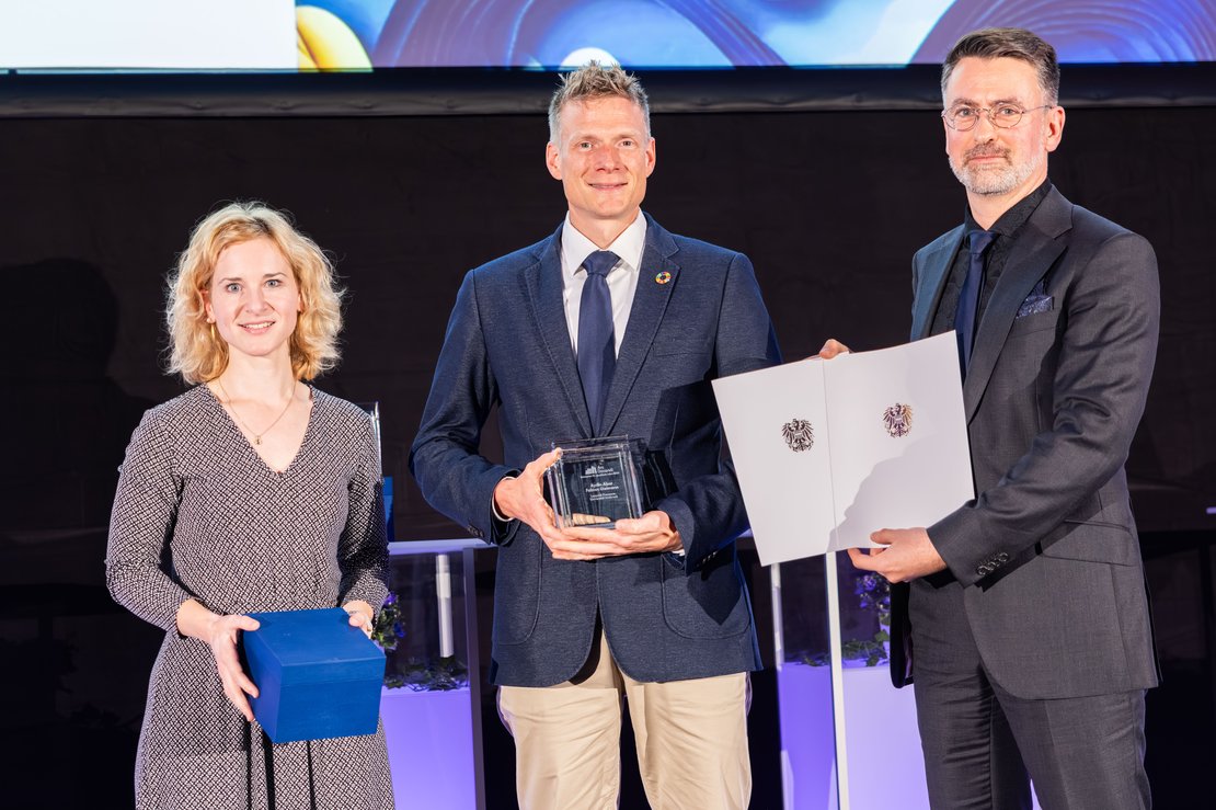Drei Personen mit Urkunden in der Hand