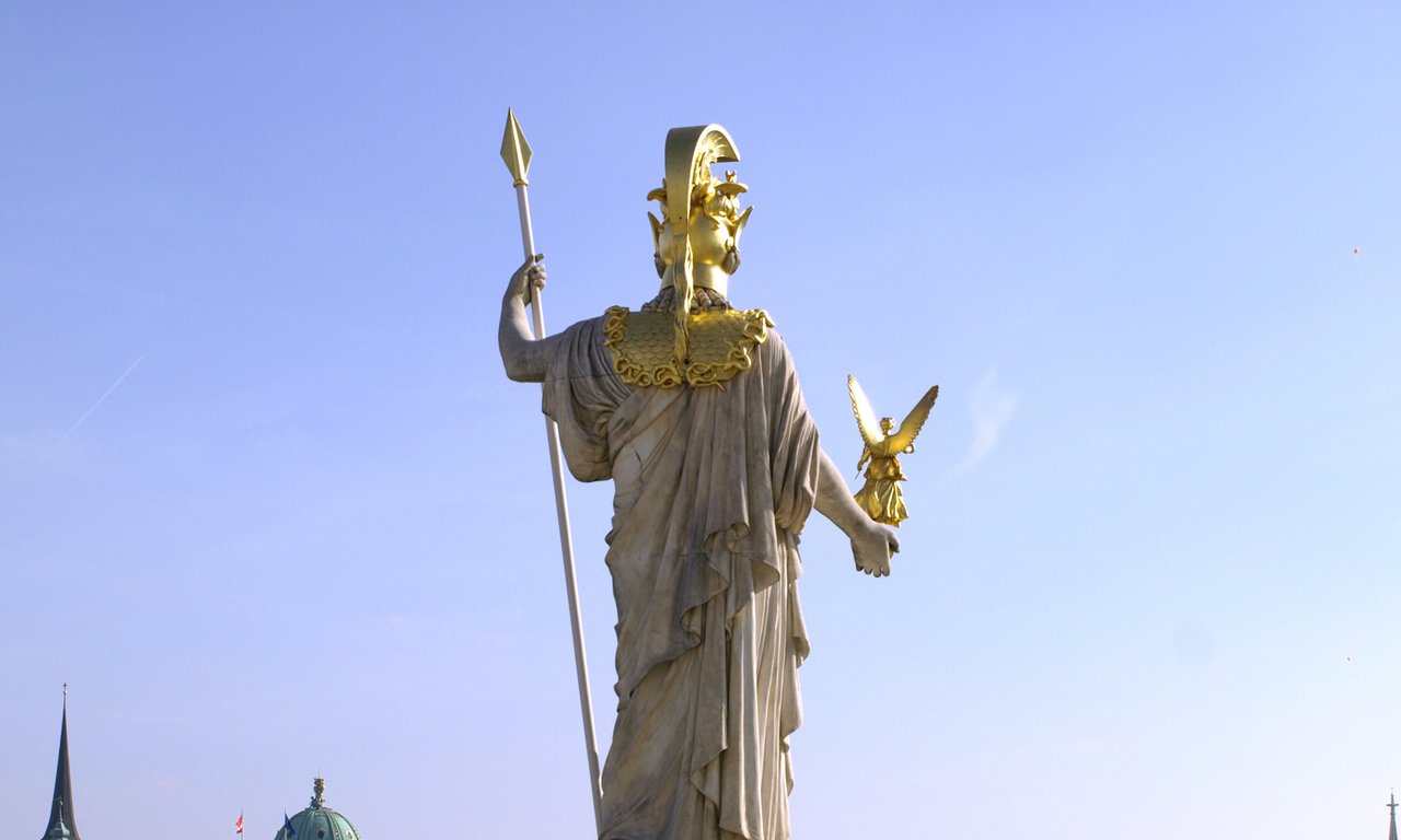 Statue, in der linken Hand ein Speer, in der rechten ein Engel, von hinten