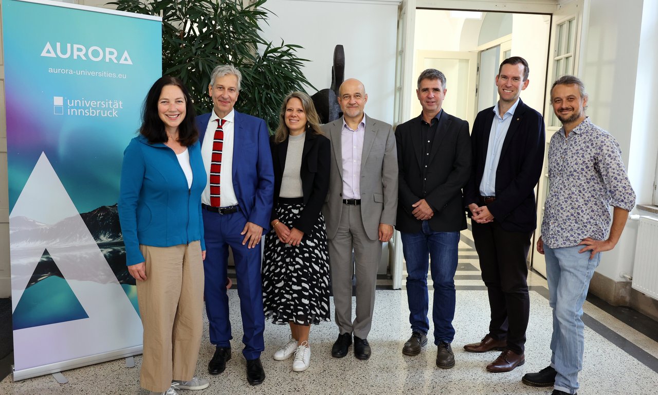 Gruppenfoto, links im Hintergrund ein Roll-up mit Aurora-Schriftzug und -Logo.