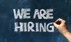 Zu sehen ist eine Schiefertafel mit dem Schriftzug "We are hiring".