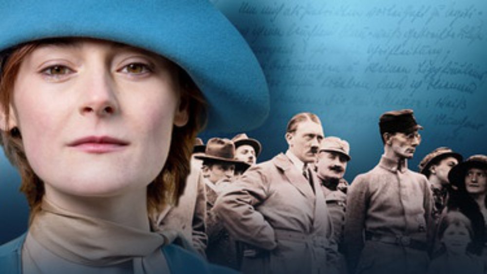 Person mit einem blauen Hut, im Hintergrund Adolf Hitler und weitere Personen