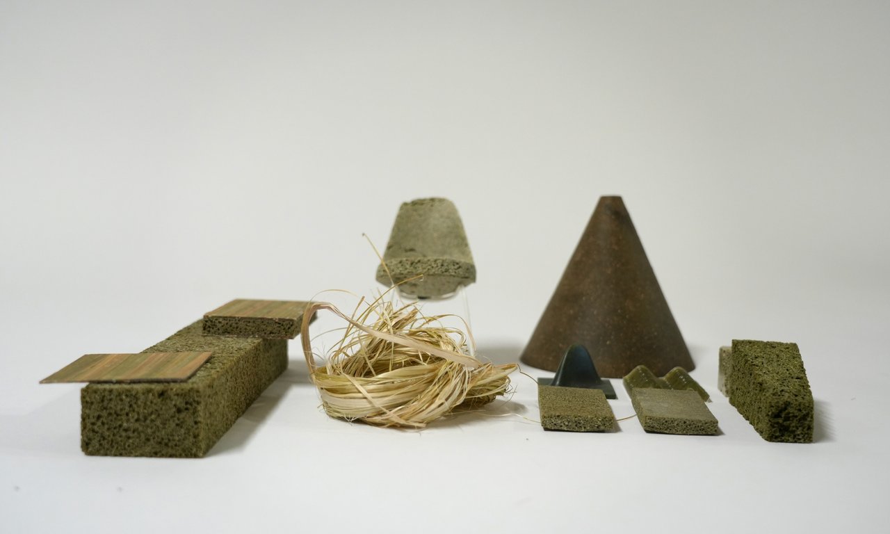Mehrere dunkelgrüne Quader und Pyramiden stehen auf einer Oberfläche
