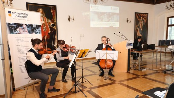 A string trio in a festive hall plays music
