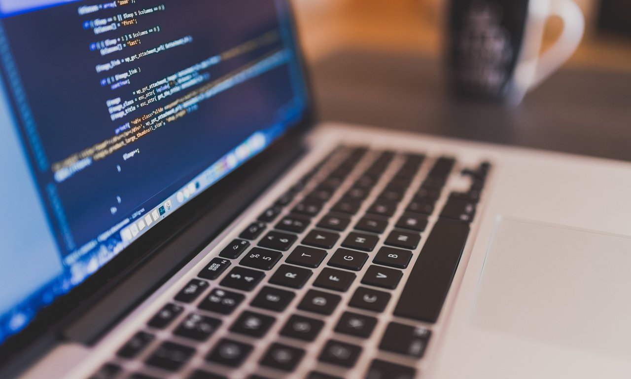 Offener Laptop, auf dem Bildschirm ist Code