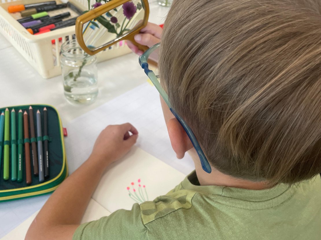 Kind zeichnet Blumen