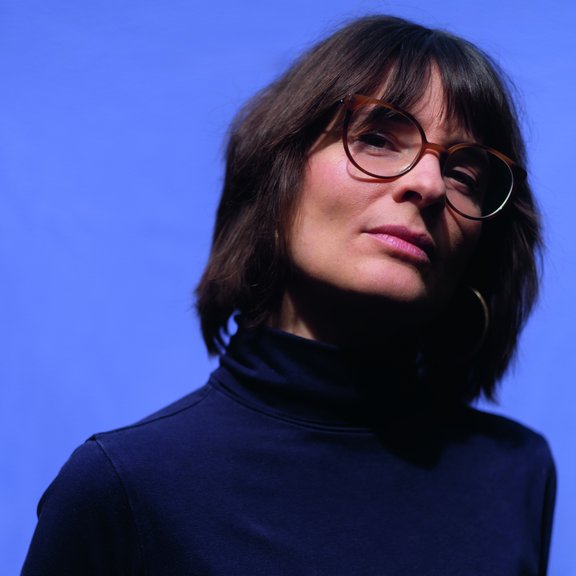 Portrait Rebekka Endlers auf einem blauen Hintergrund