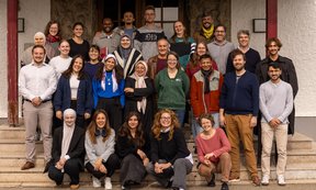 Teilnehmende der Studienwoche stehen in vier Reihen auf den Stufen vor dem Eingang ins Gebäude, wo die Studienwoche stattgefunden hat.