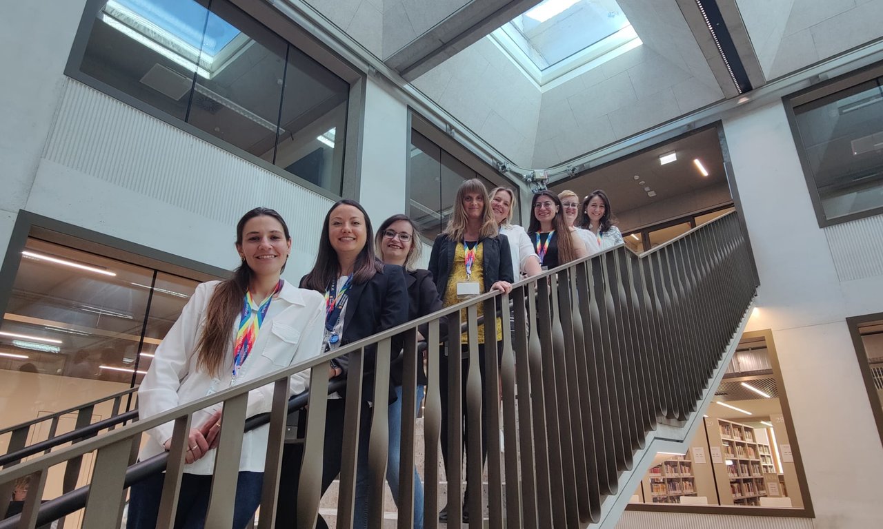 Acht Frauen stehen auf einer Treppe, die meisten davon eher jung