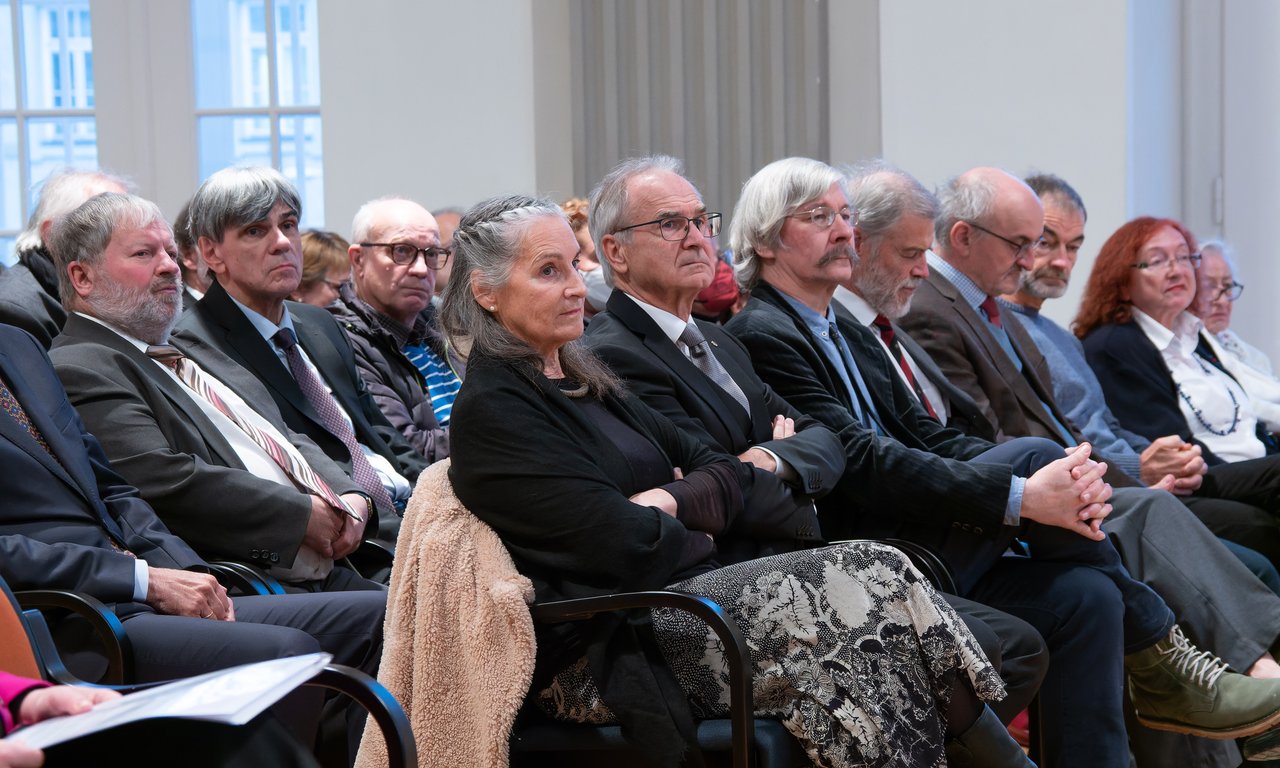 Einige Personen im Publikum blicken auf die Bühne