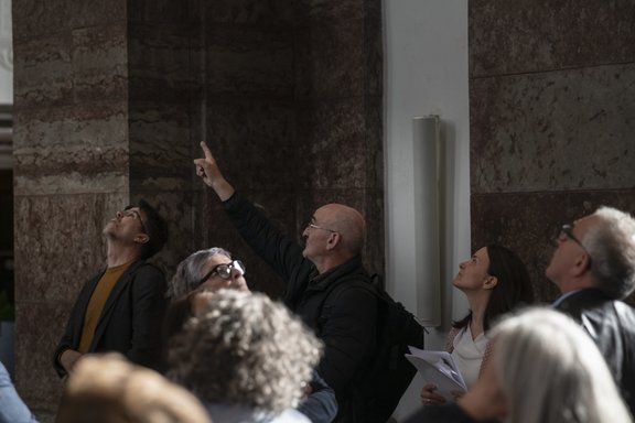 Ein Mann deutet in einer Kirche nach oben