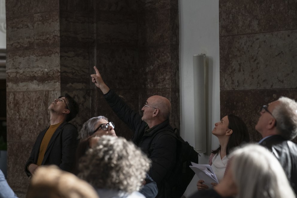 Ein Mann deutet in einer Kirche nach oben