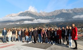 Die zahlreichen Teilnehmer*innen des Kurses „Angewandte Personalforschung“ auf dem Dach der Tirol Kliniken. Im Hintergrund die Nordkette, Blauer Himmel und Wolken.