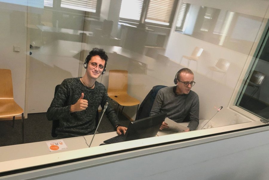 Zwei Studierende in einer Dolmetschkabine.