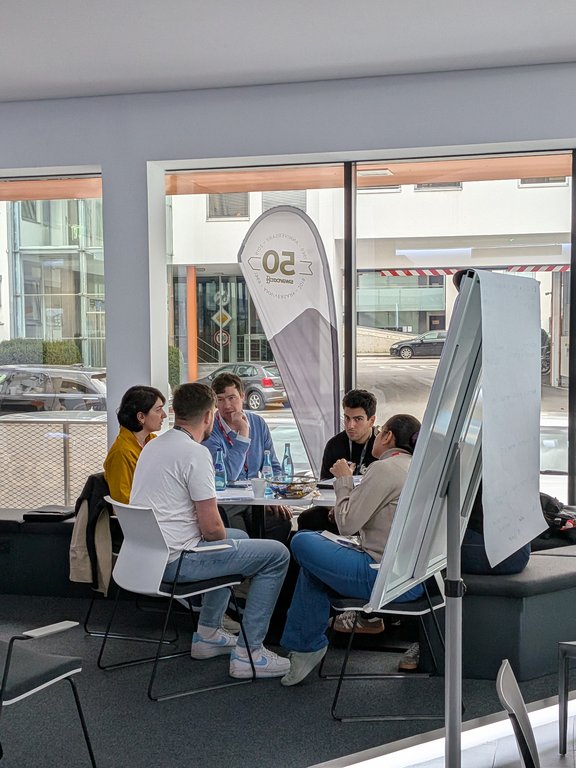 zeigt 5 Studierende im kreis beim Gespräch