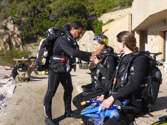 dive instructor with to students getting ready for their first try dive