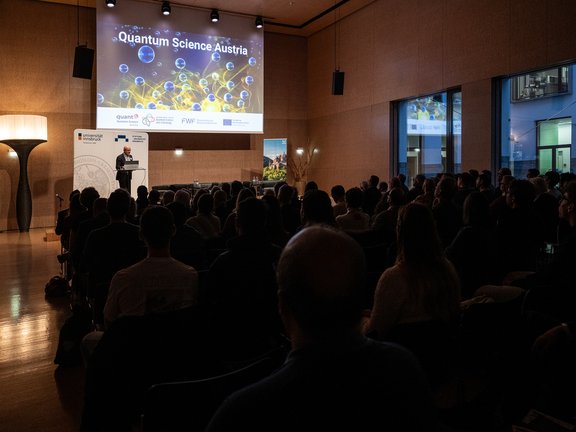 Foto von Gregor Weihs auf der Bühne und Publikum