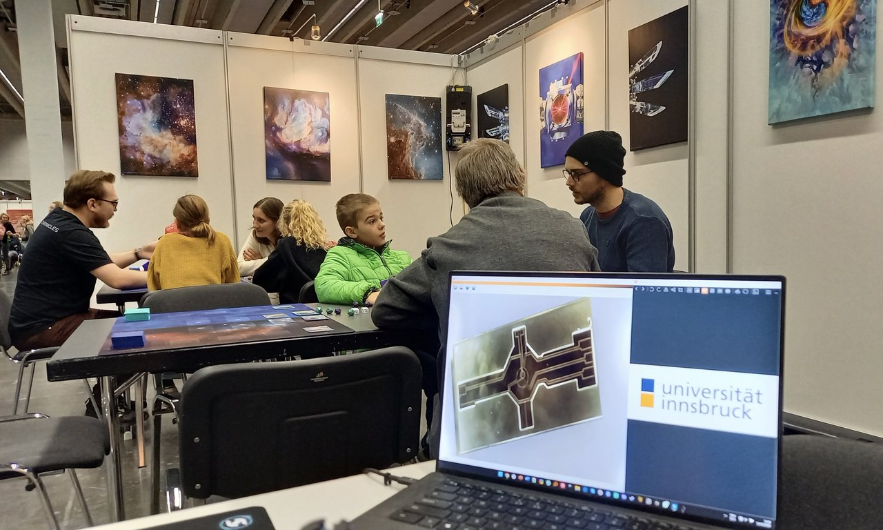 Der Bildschirm eines Laptops, im Hintergrund spielende Menschen