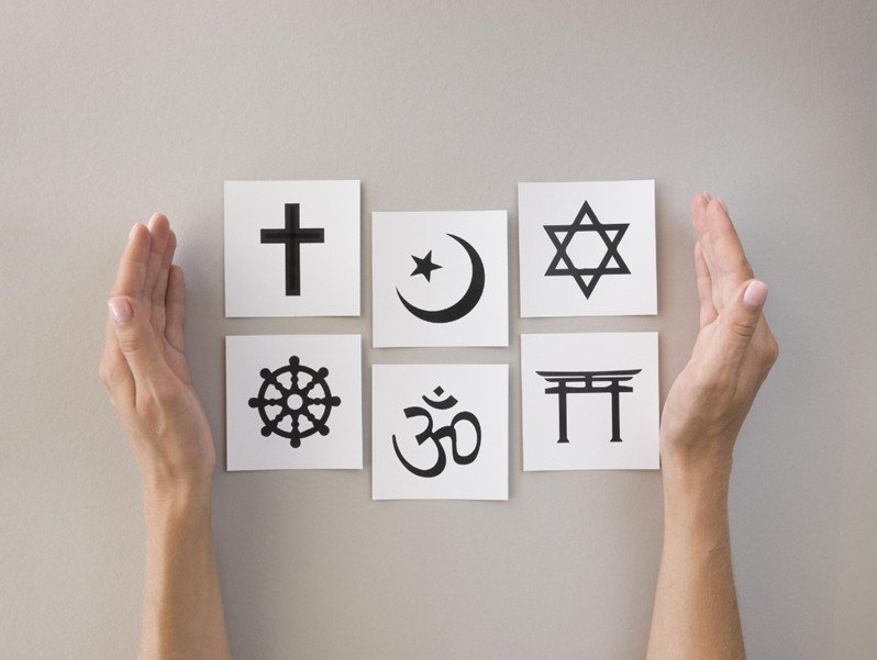 Zu sehen sind viereckige Kärtchen, auf diesen sind die jeweiligen Symbole der großen Weltreligionen gedruckt.