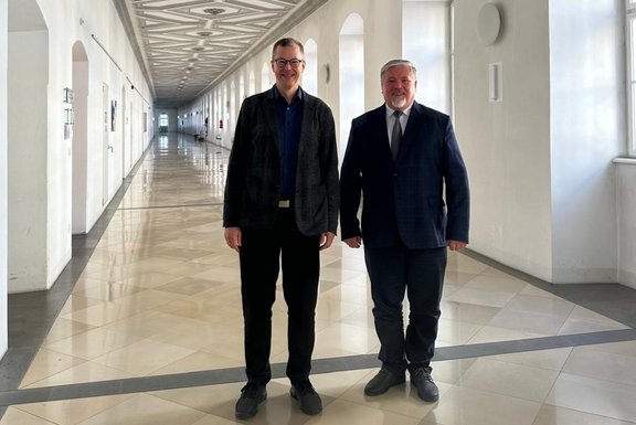 Zu sehen sind , Univ.-Prof. Dr. Liborius Lumma (Liturgiewissenschaft) und Prof. Dr. Viorel Sava im Gebäude der Theologischen Fakultät.