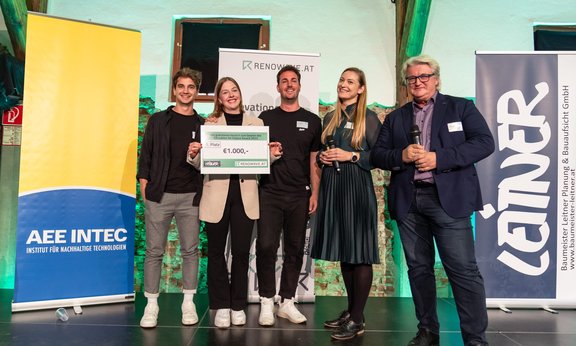 Gruppenfoto von fünf Personen auf einer Bühne.