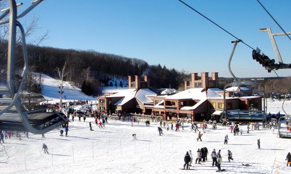 Blick auf ein Skigebiet, im Hintergrund Gebäude