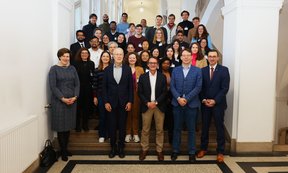 Rund 40 Personen auf einem Gruppenfoto im Treppenbereich des Uni-Haupgebäudes.