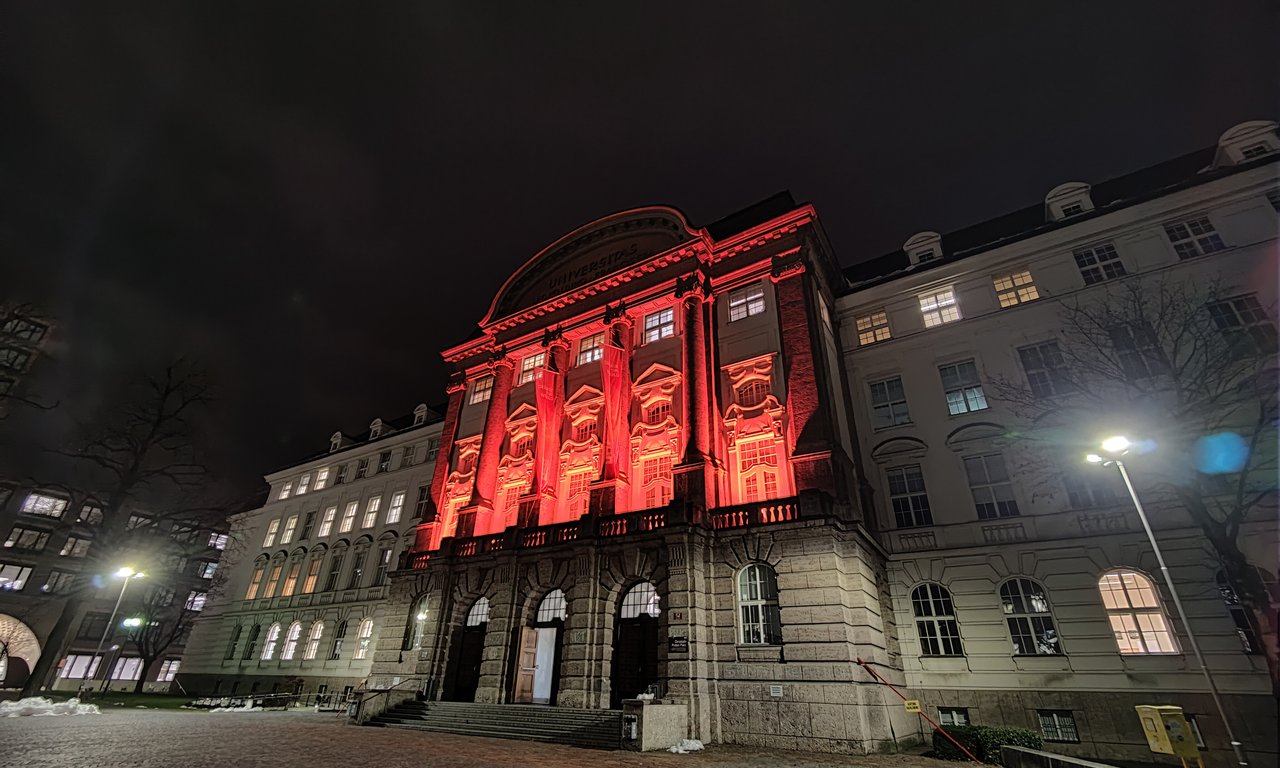 Das Hauptgebäude der Universität Innsbruck, orange beleuchtet.