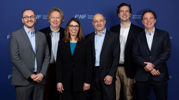Sechs Personen vor einem blauen Hintergrund