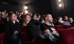 Zuschauer:innen sitzen in einem Kinosaal