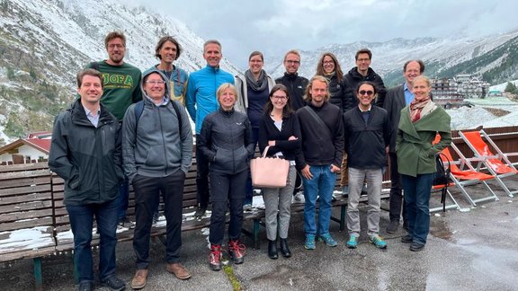 Group photo of the participants of the retreat, with snow-covered mountains in the background