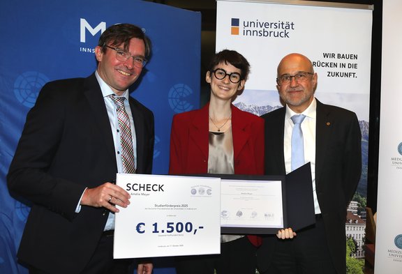 Drei Personen mit Urkunde