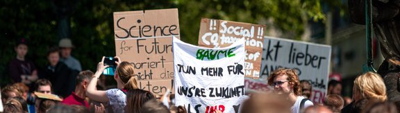 Demonstranten halten Schilder auf einer überfüllten Klimaprotestkundgebung